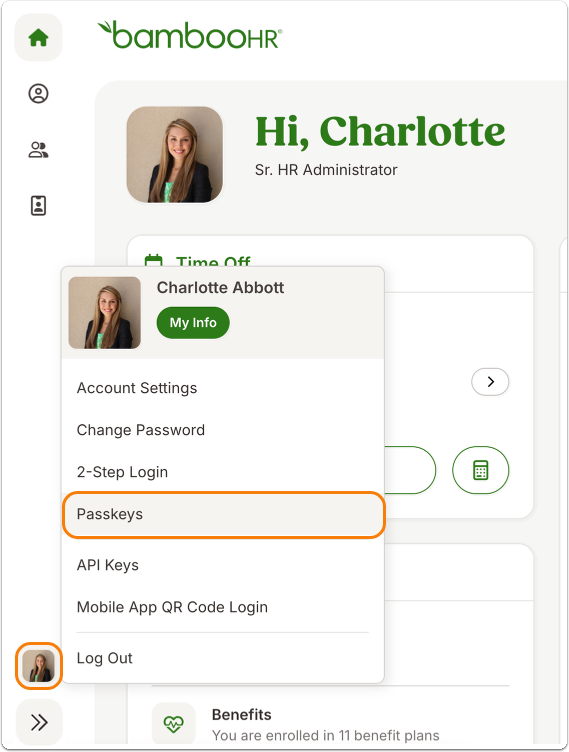 Screenshot of the BambooHR dashboard showing the profile dropdown for a sample employee labeled “Charlotte Abbott.” Menu options include Account Settings, Change Password, 2-Step Login, Passkeys, API Keys, and Mobile App QR Code Login, with Passkeys outlined in orange. The profile icon in the bottom-left corner is also highlighted, indicating where to click to open this menu.
